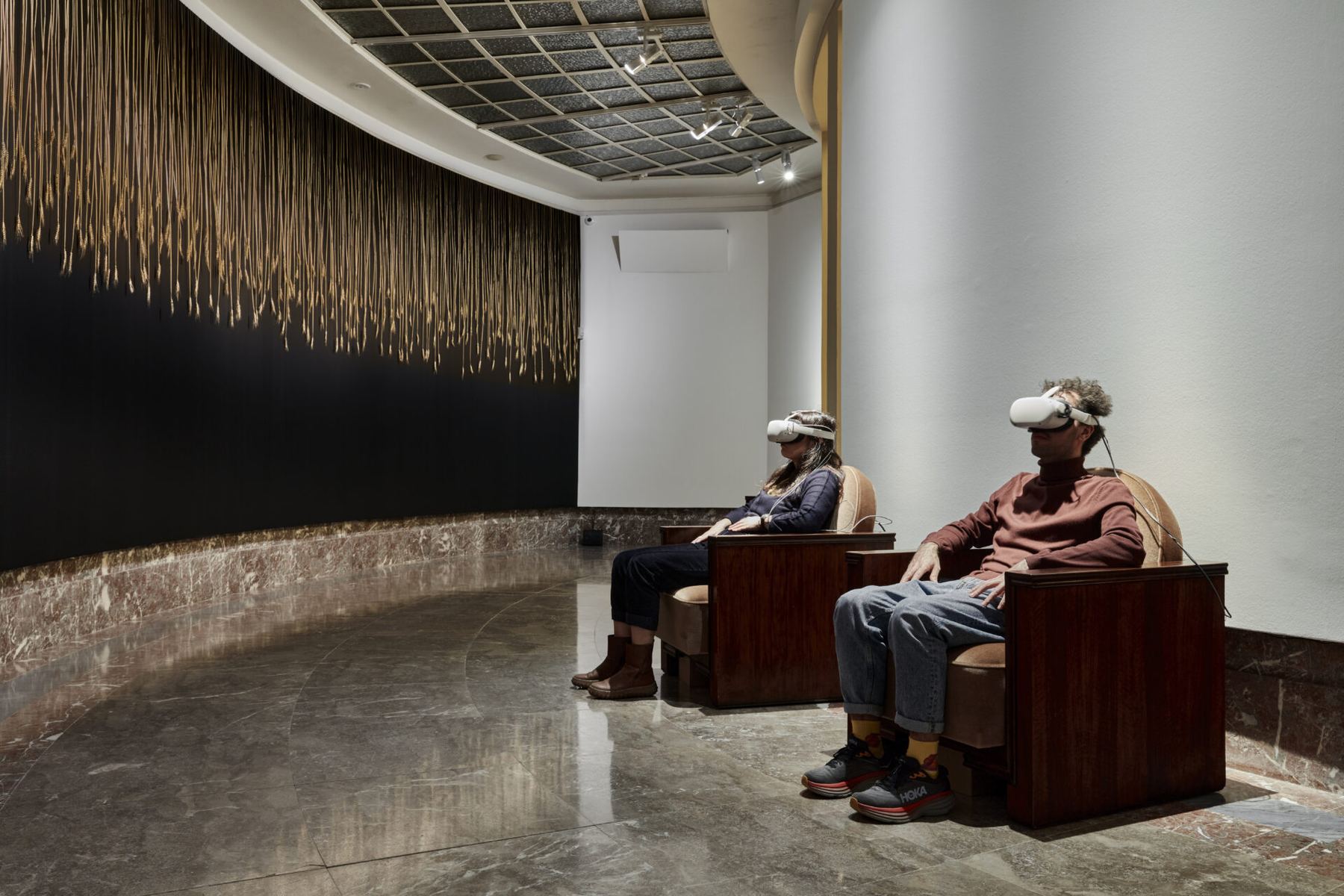 Two visitors in armchairs wearing VR headsets in a gallery